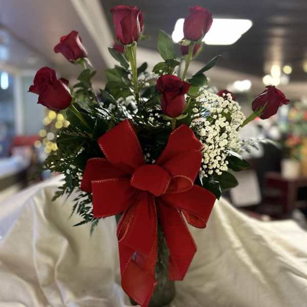 Red roses in a vase with a large red ribbon