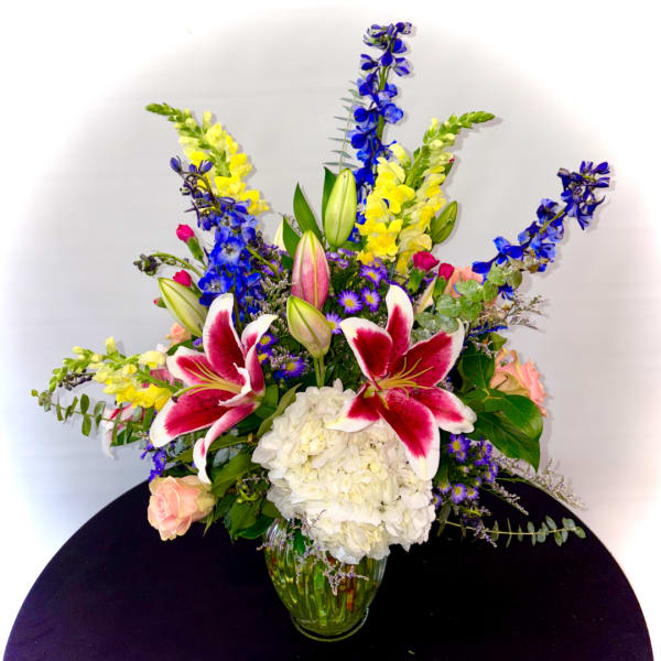 Colorful bouquet with lilies, hydrangea, and snapdragons in a glass vase