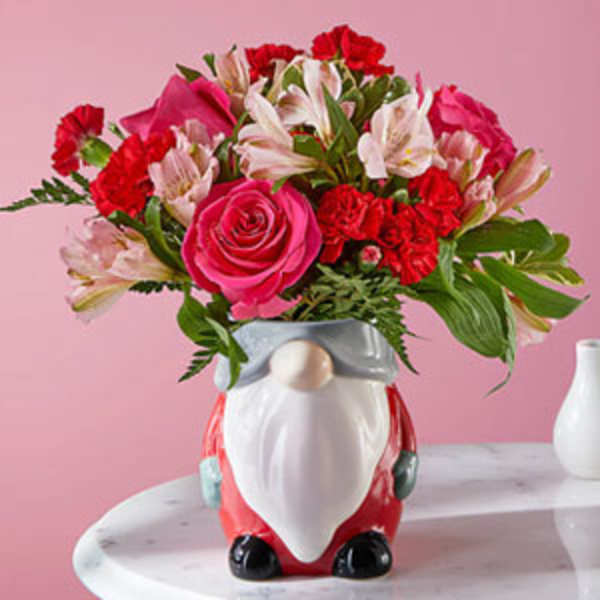 Pink and red flower arrangement in a Santa-shaped vase