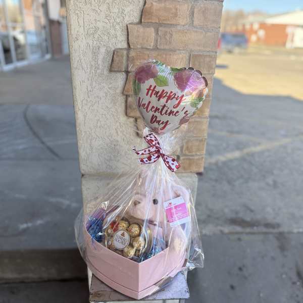 Valentine's Day gift basket with a heart balloon, teddy bear, and chocolates