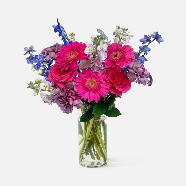 Bouquet of pink and purple flowers in a clear glass vase