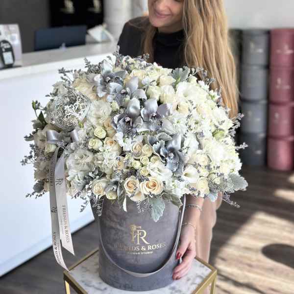 Large bouquet of white and silver flowers in a gray hatbox