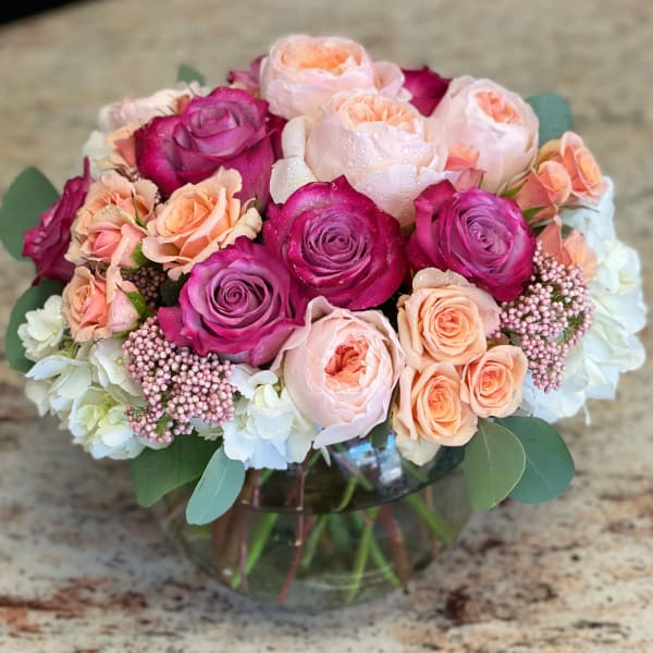 Bouquet of pink and peach roses in a glass vase