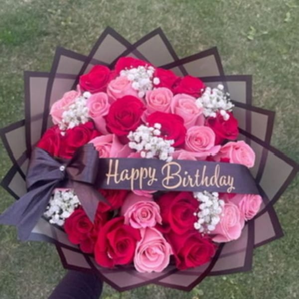 Bouquet of pink and red roses with a Happy Birthday ribbon