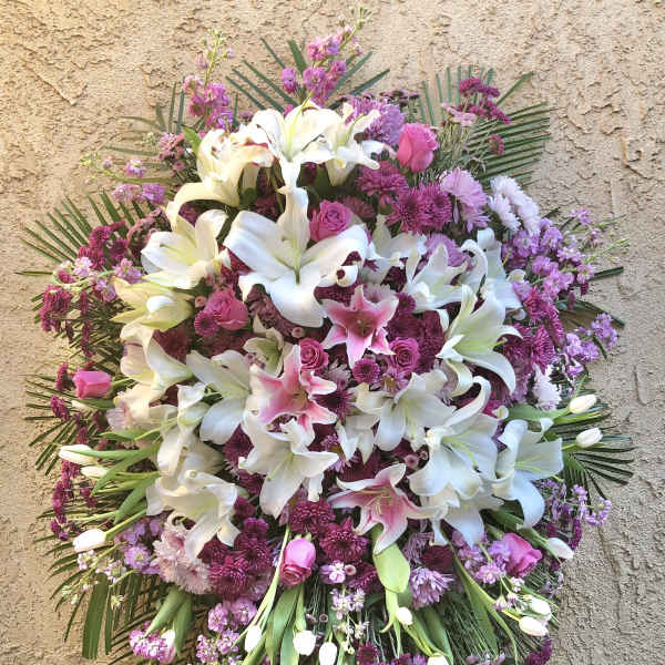 Large standing spray of white lilies and pink flowers on an easel