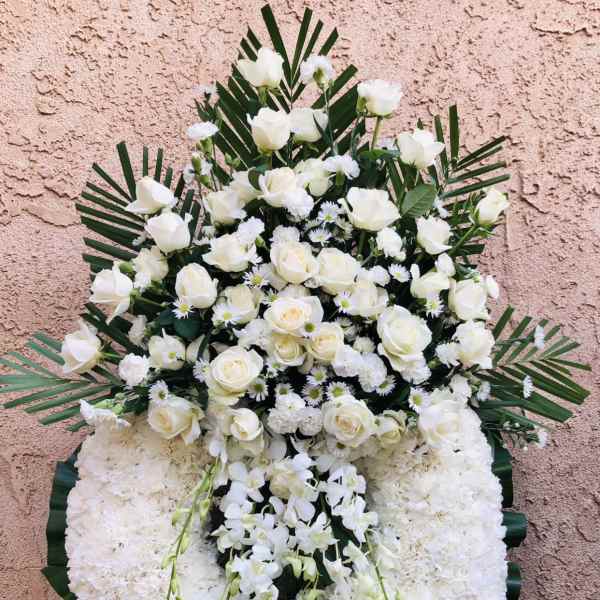 Large white funeral wreath with roses and orchids