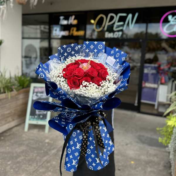 Bouquet of red roses with white baby's breath in blue patterned wrap