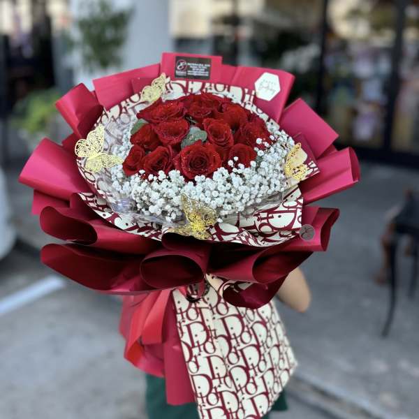 Bouquet of red roses with white baby's breath in pink wrapping