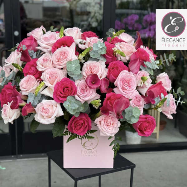 Pink and white rose arrangement in a pink box with eucalyptus