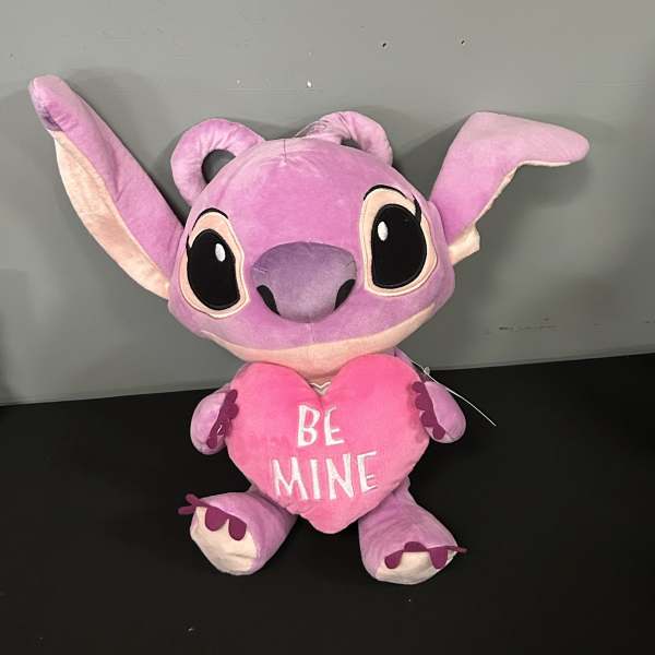 Pink plush character holding a heart that says "BE MINE"