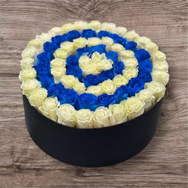 Round box of blue and cream roses arranged in a spiral pattern