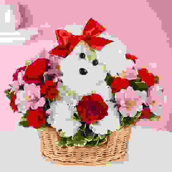 White teddy bear in a basket with red bows and pink flowers