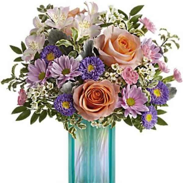 Bouquet of peach roses and purple daisies in a turquoise glass vase