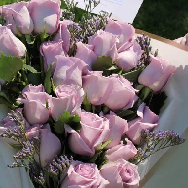 Bouquet of pale pink roses with purple filler flowers