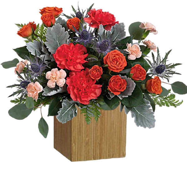Orange and red roses with carnations in a wooden cube vase