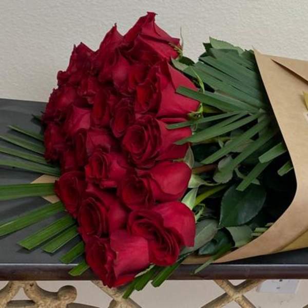 Bouquet of red roses wrapped in brown and gold paper