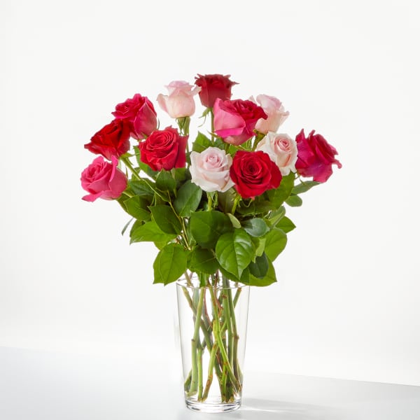 Bouquet of red and pink roses in a clear glass vase
