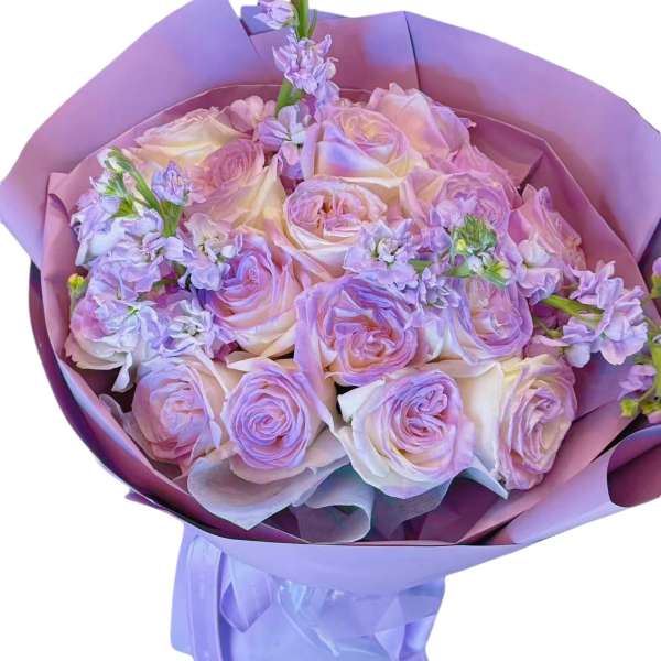 Lavender and blush rose bouquet wrapped in purple paper