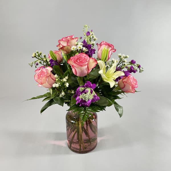 Pink roses and white lilies in a glass vase