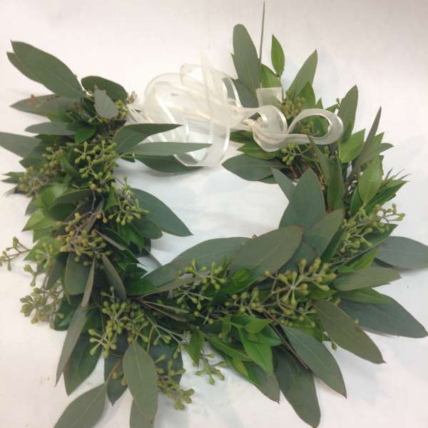 Green foliage wreath with a white ribbon bow