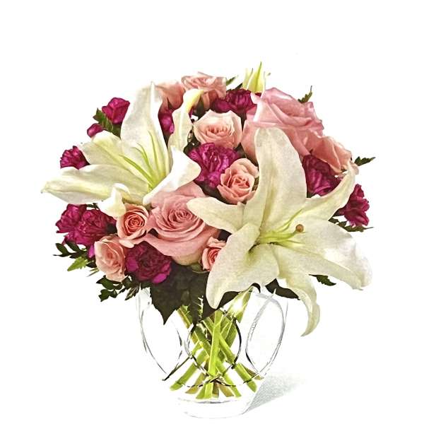 Pink roses and white lilies in a clear glass vase