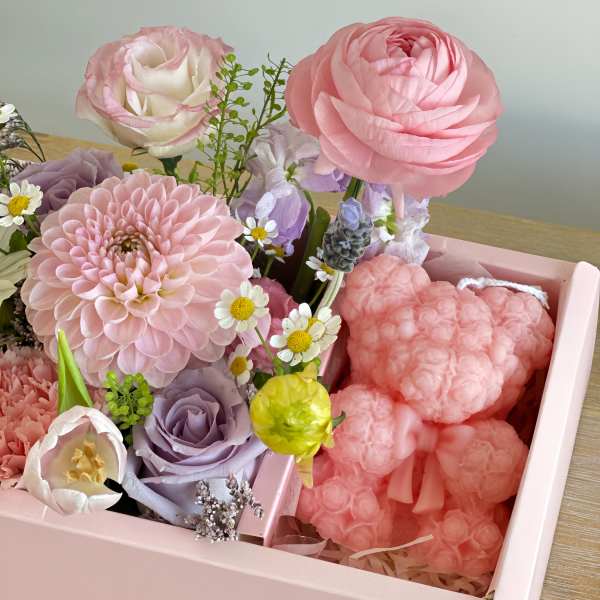 Pink and lavender floral arrangement in a pink box with a heart-shaped plush
