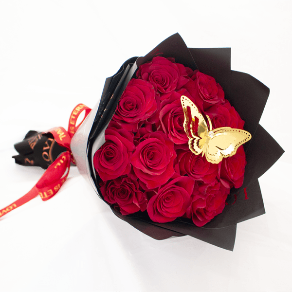 Bouquet of red roses wrapped in black paper with a butterfly decoration