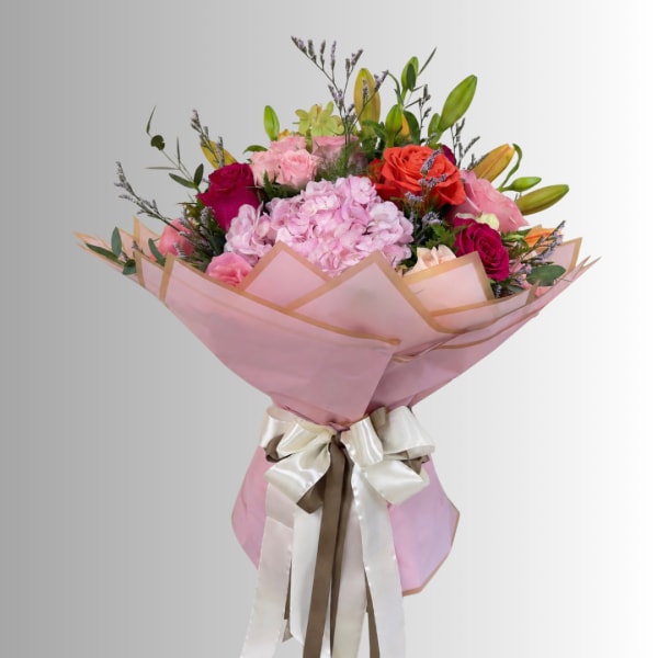 Bouquet of pink and red roses with hydrangea wrapped in pink paper