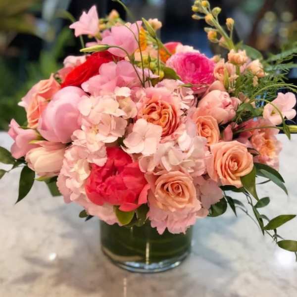 Pink and peach mixed flower bouquet in a glass vase