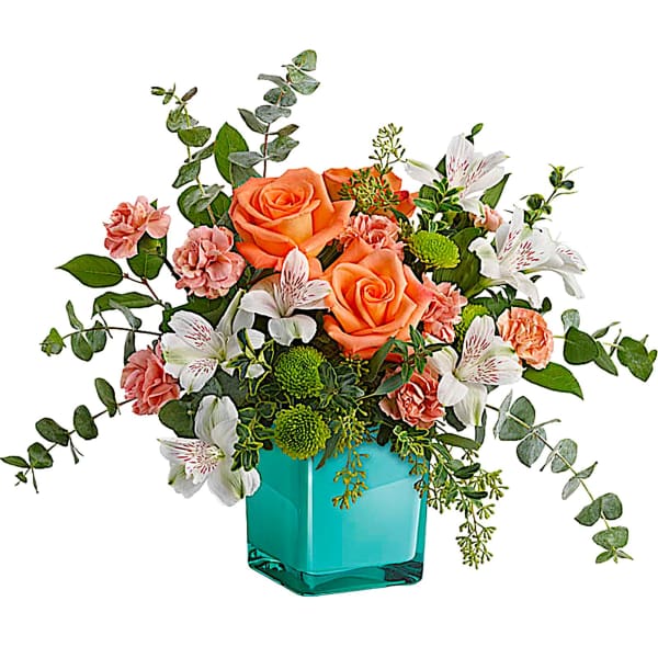 Orange roses and white lilies in a turquoise vase
