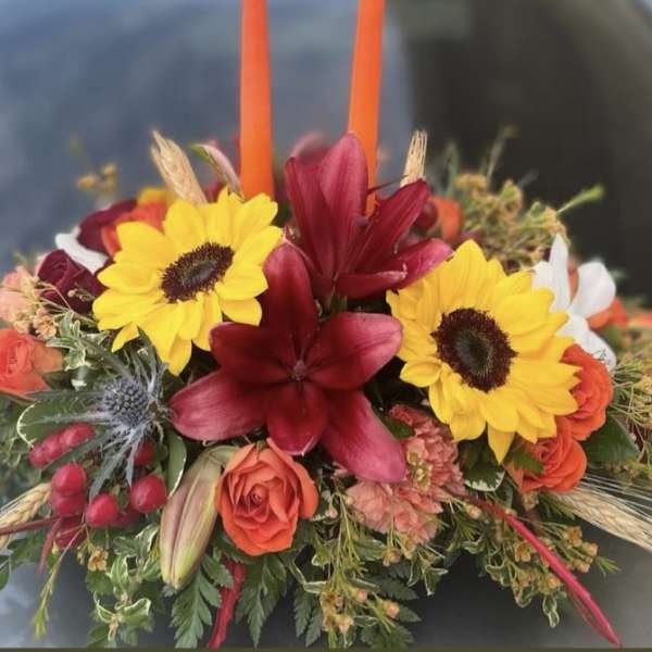 Colorful floral arrangement with sunflowers, red lilies, and orange roses
