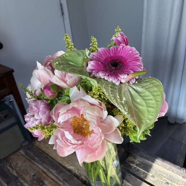 Pink and white bouquet in a glass vase with a bright pink gerbera daisy