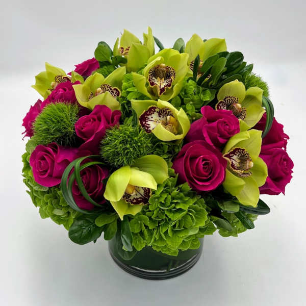 Bouquet of magenta roses and green orchids in a dark vase
