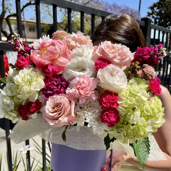 Large bouquet of pink, white, and lime flowers in a lavender box