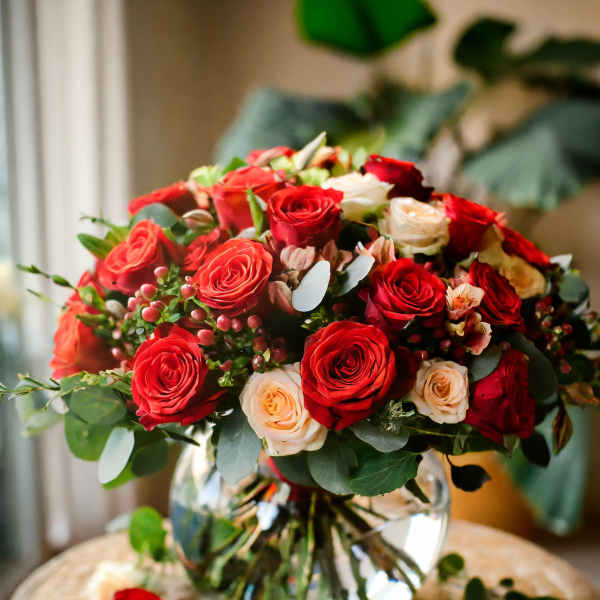 Bouquet of red and cream roses in a clear glass vase