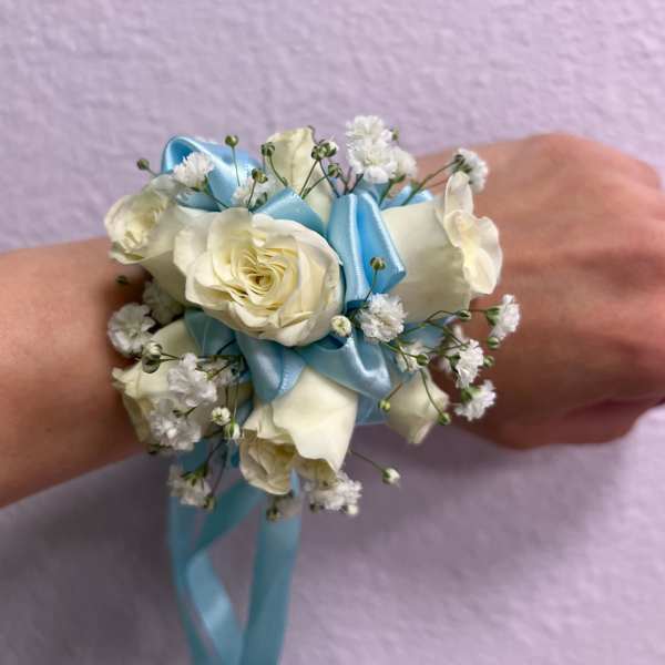 White rose wrist corsage with blue ribbon and baby's breath