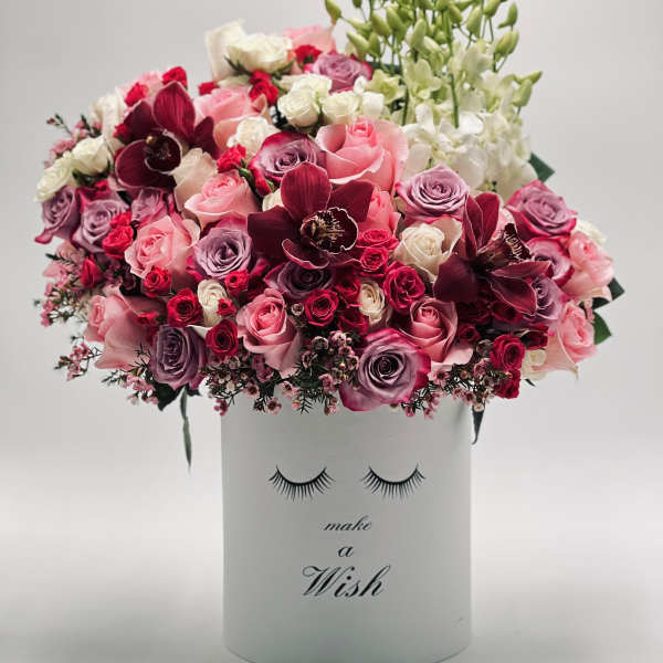 Pink and burgundy roses with orchids in a white box