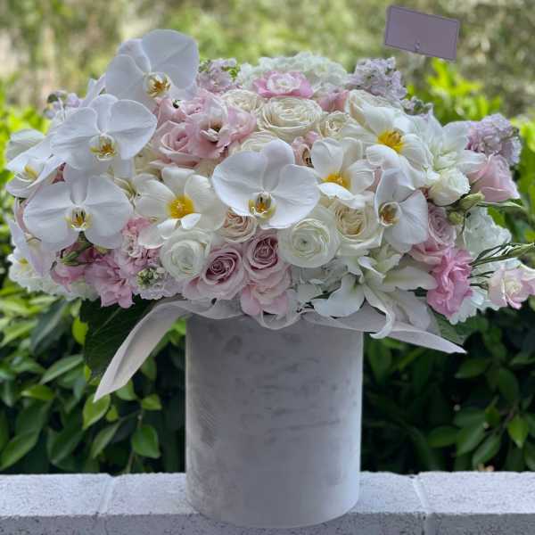 Pink and white floral arrangement in a tall gray vase