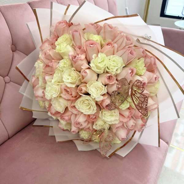 Bouquet of pale pink and cream roses wrapped in white paper