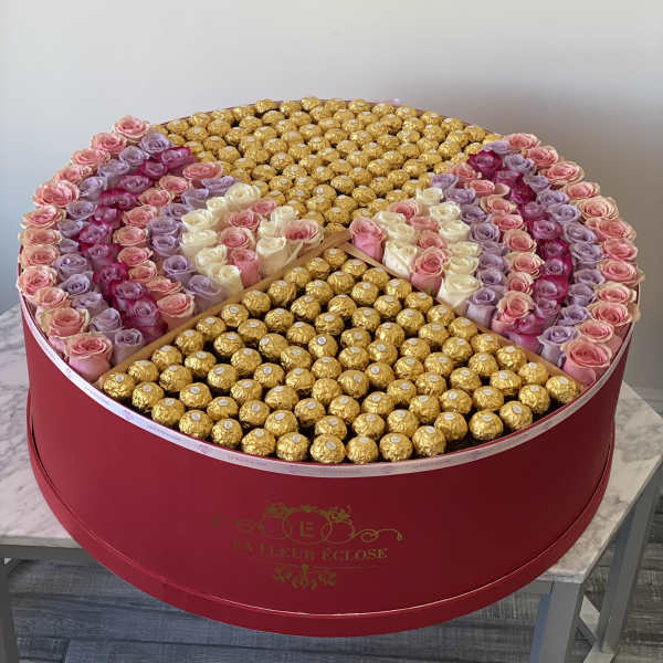 Round box of pink and lavender roses with gold-wrapped chocolates