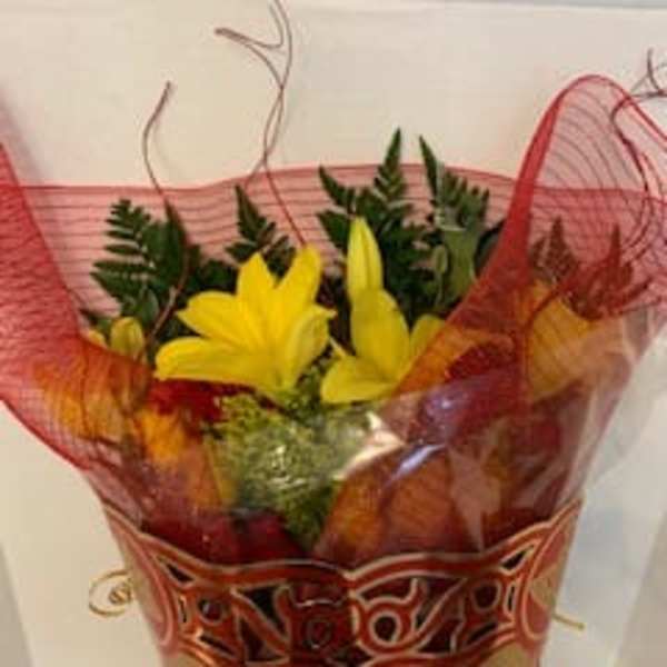 Bouquet of yellow lilies wrapped in red mesh paper