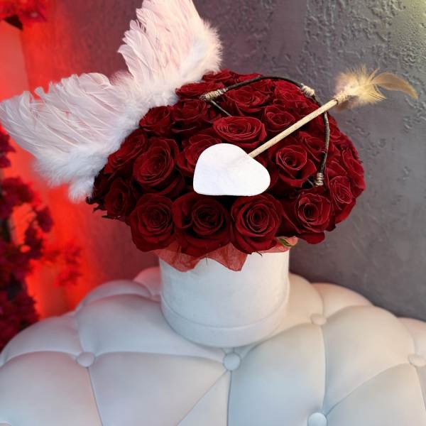Red rose arrangement with white wings and a heart accent in a white box