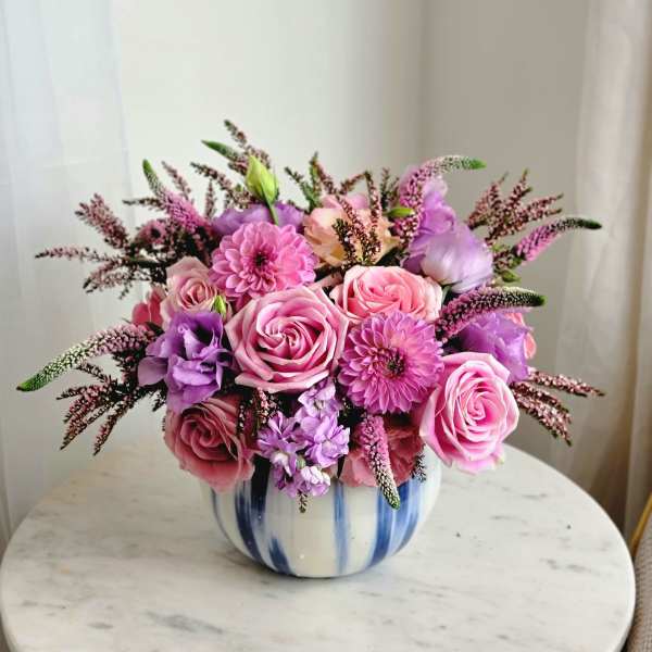 Pink and purple flower arrangement in a blue-and-white ceramic vase