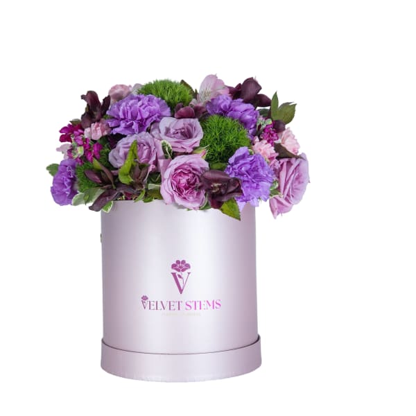 Purple floral arrangement in a lavender hat box
