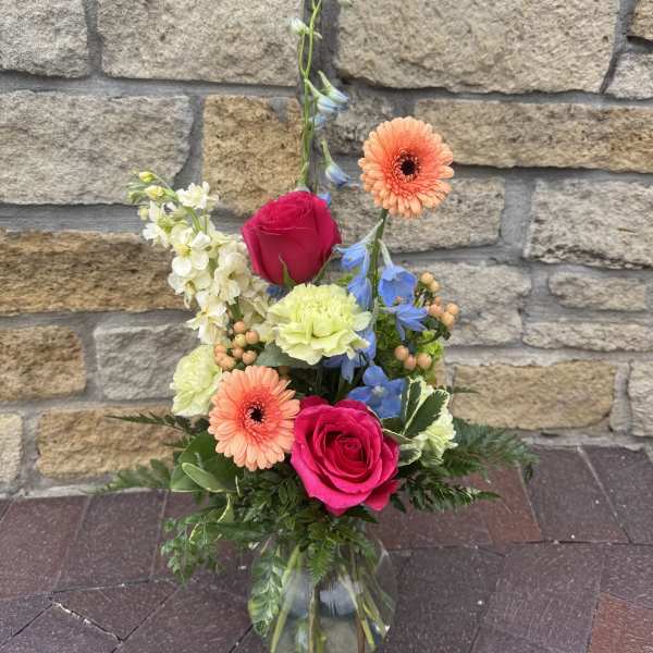 Mixed bouquet in a clear glass vase with pink roses and peach gerbera daisies
