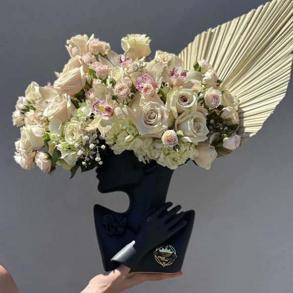 Cream rose bouquet with orchids and hydrangeas in a black holder