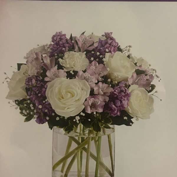 White and lavender bouquet in a clear glass vase