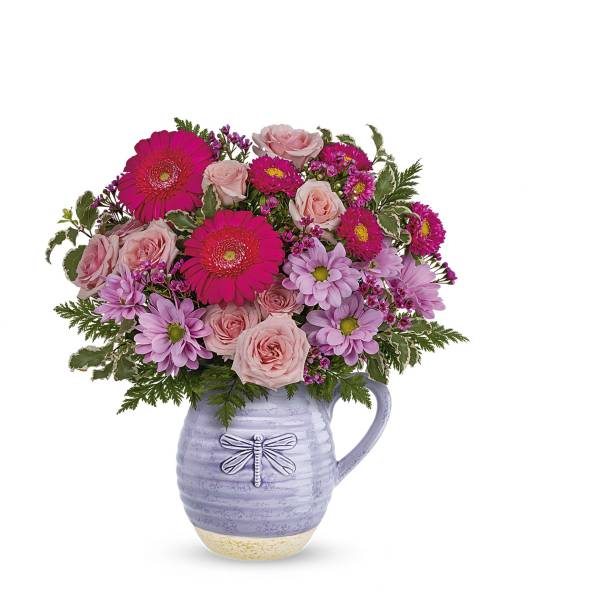 Pink and lavender flowers arranged in a lavender pitcher vase
