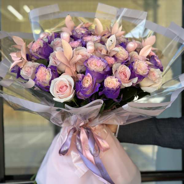Bouquet of pink and purple roses wrapped in pastel paper