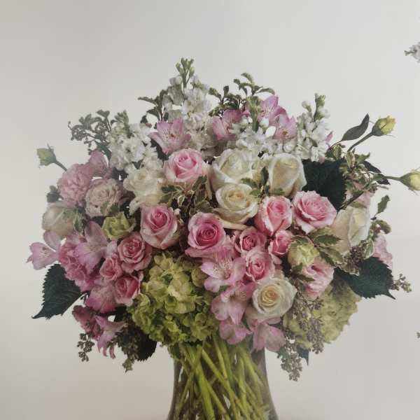Pink and white rose bouquet in a clear glass vase